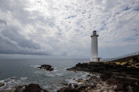 White lighthouse on a steep coast. Dramatic clouds with a view of the sea, pure Caribbean at Le