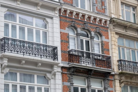Detailed view of a classically designed brick facade with white window frames, Blankenberge,