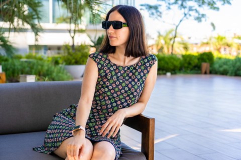 A young wioman is sitting on a couch outdoors