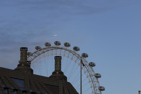 Airbus A319-100 aircraft of British airways in flight over the pods of the London Eye or Millennium