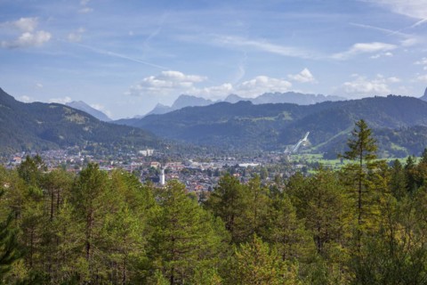 Overview of Garmisch-Partenkirchen with Karwendel mountains and forest in autumn, hiking trail