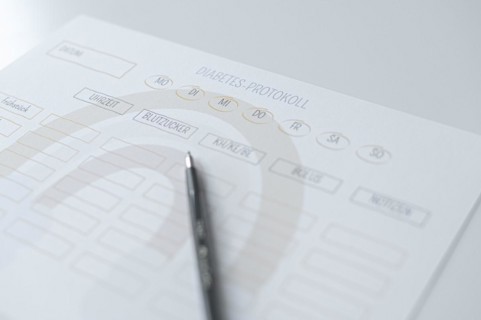Diabetes log, daily log of food and insulin administration, food log, the paper lies on a white