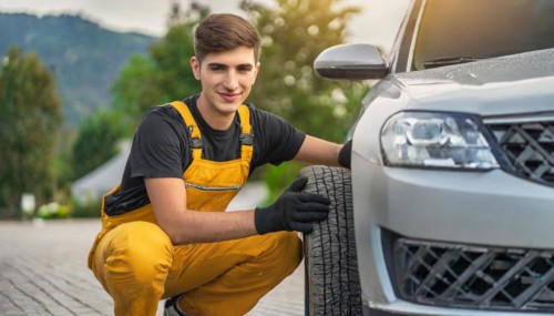 AI generated, A mechanic changes the tyres on a customer's car, tyre fitting, silver car
