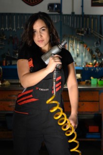 Empowered curvy hispanic sexy woman mechanic holding an air compressor hose in a dynamic pose in