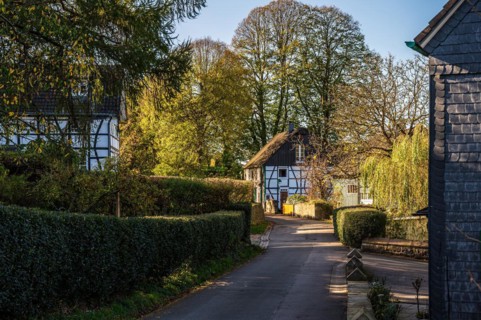 A quiet village street with traditional half-timbered houses on a sunny spring day, Schee,