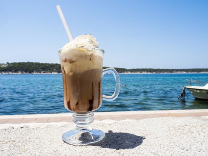 Iced coffee with whipped cream, the sea in the background, Rab Island, Kvarner Gulf Bay, Croatia,