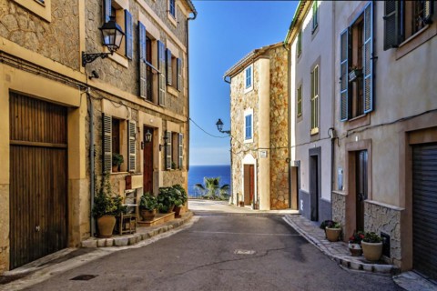 Charming village street with traditional buildings and decorative flower pots, Hiking tour from