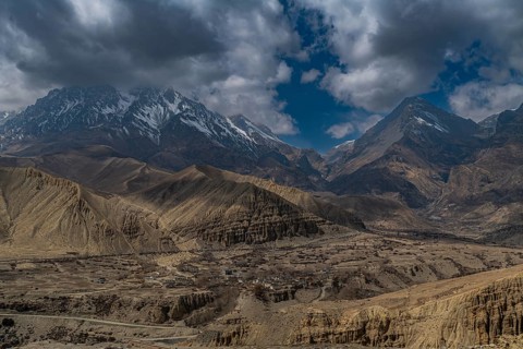 Desert landscape before a snowcapped mountain range, Kingdom of Mustang, Nepal, Asia