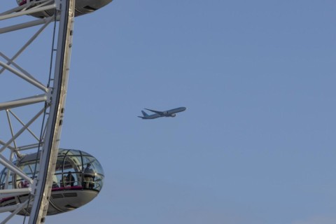 Aircraft of Korean airways in flight behind the pods of the London Eye or Millennium Wheel, London,