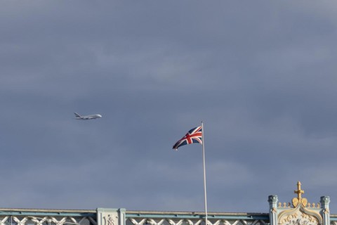 Airbus A380 aircraft of Emirates airlines in flight with a Union Jack flag on Tower Bridge in the