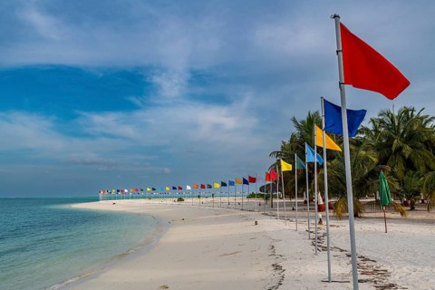 White sand beach with many flags, Bangaram island, Lakshadweep archipelago, Union territory of