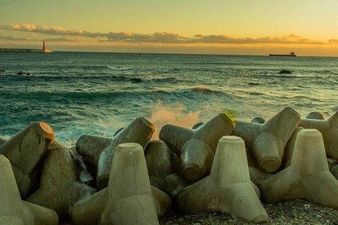 Seascape with concrete tetrapods on breakwater during dusk, creating a tranquil scene, in South