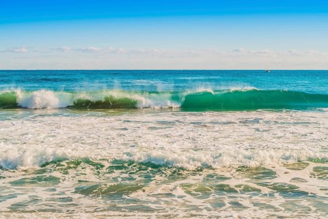 A curling wave in the ocean captures the essence of a sunny day, in South Korea