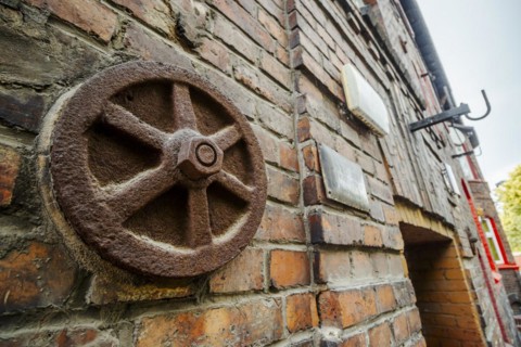 Metal rusted ankra protects house from damage on wobbly post-mining land, Katowice, Nikiszowiec,