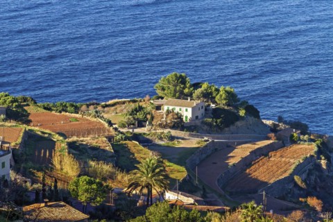 Coastal landscape with a house and terraced fields overlooking the blue sea, Hiking tour from