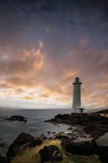 White lighthouse on a steep coast. Dramatic clouds with a view of the sea, pure Caribbean at Le
