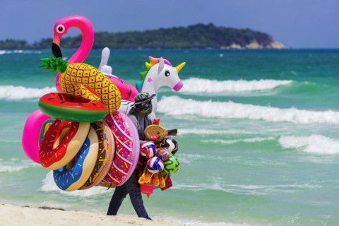 Merchant on the beach selling inflatable swimming aids, colourful, swimming, beach vendor, holiday,