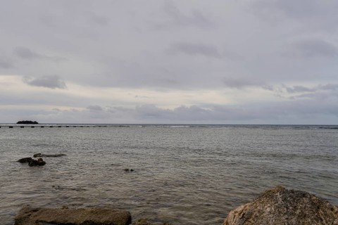 Seascape of the pacific ocean with a rocky shoreline taken in Guam on a cloudy day in Guam