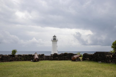 White lighthouse on a steep coast. Dramatic clouds with a view of the sea, pure Caribbean at Le
