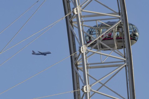 Airbus A319-100 aircraft of British airways in flight behind the pods of the London Eye or