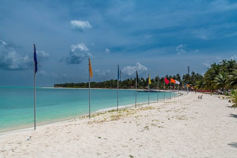 White sand beach with many flags, Bangaram island, Lakshadweep archipelago, Union territory of