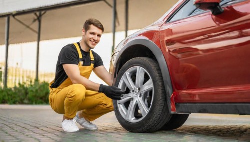 AI generated, A mechanic changes the tyres on a customer's car, tyre fitting, red car