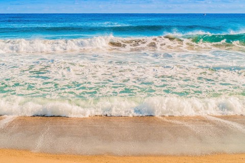 Seascape of whitecaps and waves as tide rolls in to shore on beautiful winter morning under partly