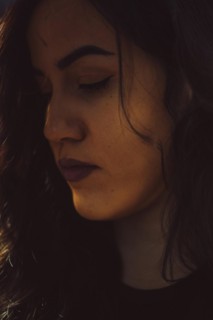 Close-up of a woman's face in a moody, introspective ambiance, a complete tool panel in background