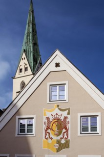 Pointed gable with royal baker's egg symbol and St.Mang church tower in Baeckerstrasse, Kempten,