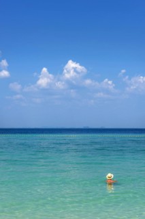 Man with hat bathing in the sun in the sea, ocean, Andaman Sea, ozone, heat, sunstroke, sunscreen,