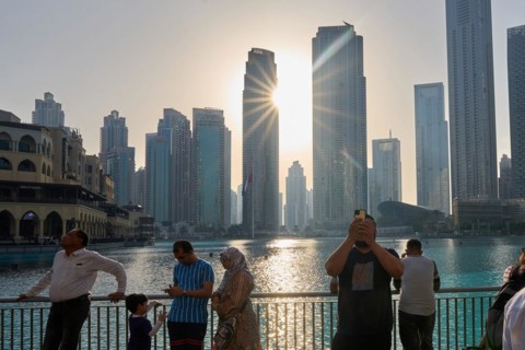 Tourists in front of the skyscraper backdrop at Lake Burj Khalifa. Dubai, United Arab Emirates,