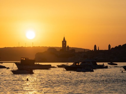 Boats anchoring in a bay, silhouette of a church tower, sunset over Rab, town of Rab, island of