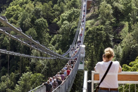 Visitors cross the rope suspension bridge at the Rappbode dam, 483 metres long, 100 metres above