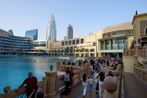 Tourists in front of the skyscraper backdrop at Lake Burj Khalifa. Dubai, United Arab Emirates,
