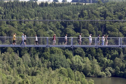 Visitors cross the rope suspension bridge at the Rappbode dam, 483 metres long, 100 metres above
