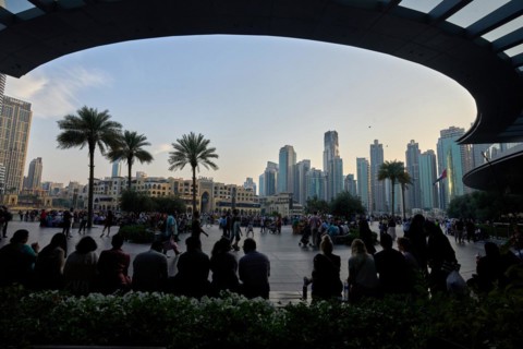 Tourists in front of the skyscraper backdrop at Lake Burj Khalifa. Dubai, United Arab Emirates,