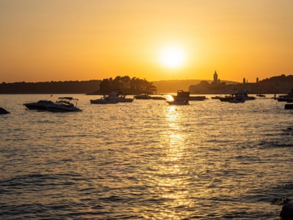 Boats anchoring in a bay, silhouette of a church tower, sunset over Rab, town of Rab, island of