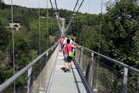 Visitors cross the rope suspension bridge at the Rappbode dam, 483 metres long, 100 metres above