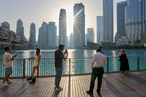 Tourists in front of the skyscraper backdrop at Lake Burj Khalifa. Dubai, United Arab Emirates,