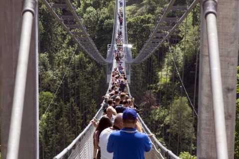 Visitors cross the rope suspension bridge at the Rappbode dam, 483 metres long, 100 metres above