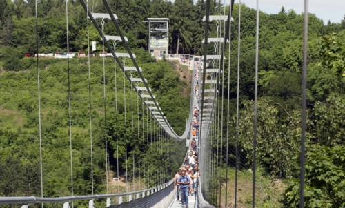 Visitors cross the rope suspension bridge at the Rappbode dam, 483 metres long, 100 metres above