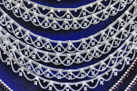 Silver jewellery necklaces with detailed patterns on a dark background, Varanasi, Uttar Pradesh,