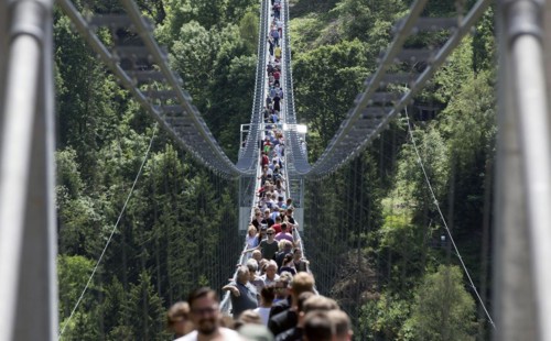 Visitors cross the rope suspension bridge at the Rappbode dam, 483 metres long, 100 metres above