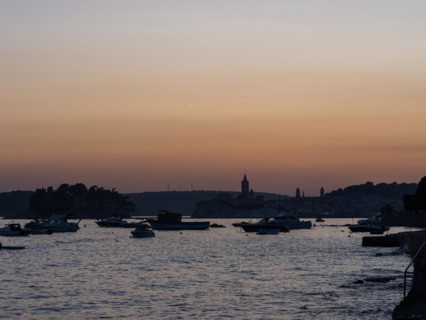 Boats anchoring in a bay, church towers, evening mood after sunset over Rab, town of Rab, island of