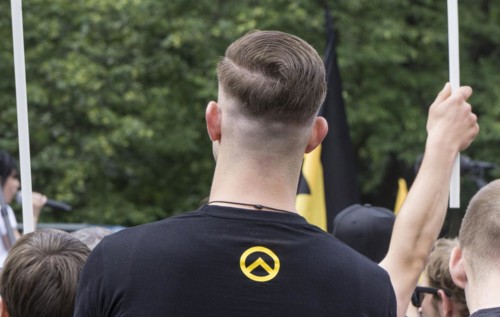 A member of the Identitarian Movement stands among the demonstrators with the Identitarian Movement