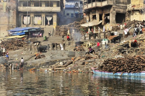Varanasi Ghats with logs for cremation rituals along the river, Varanasi, Uttar Pradesh, India,