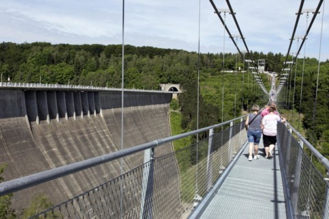 Visitors cross the rope suspension bridge at the Rappbode dam, 483 metres long, 100 metres above