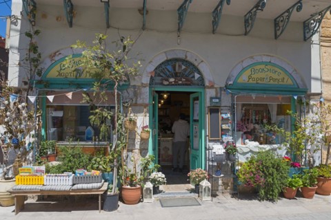 An inviting bookshop with an open door and a wide variety of articles in the entrance area, Koroni