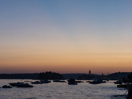 Boats anchoring in a bay, church towers, evening mood after sunset over Rab, town of Rab, island of