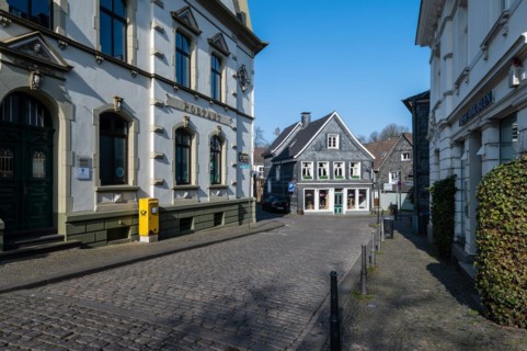 A deserted street surrounded by traditional half-timbered architecture on a clear day, Graefrath,